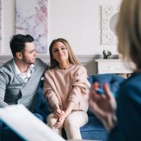 Psychological consultation. Beautiful and happy young couple visiting psychologist for relationship counseling.
